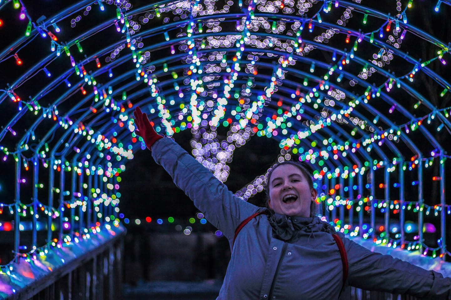 Girl jumping in light tunnel at the zoo's wild lights event