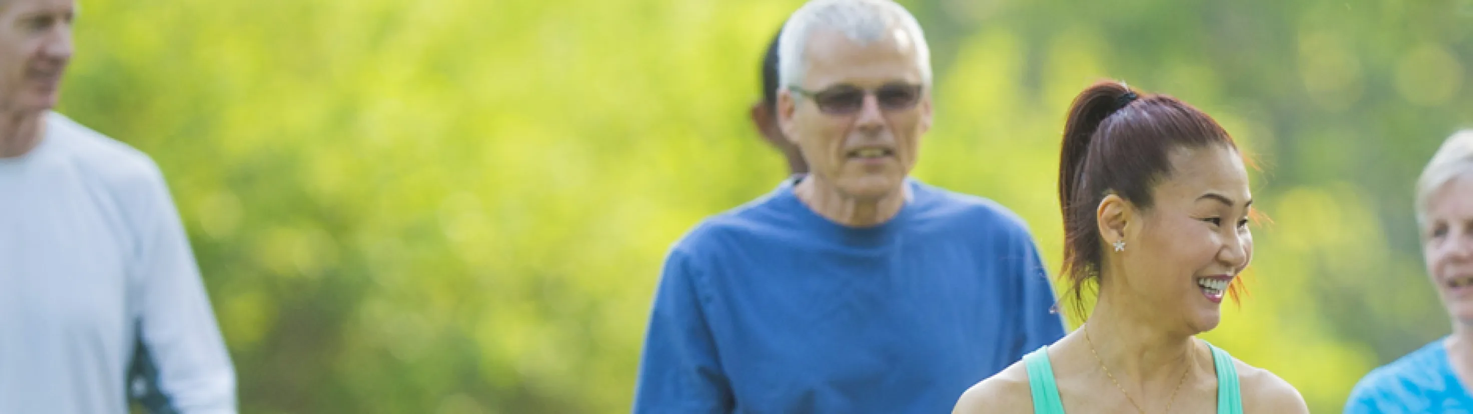 Older adults walking together outdoors in a park.