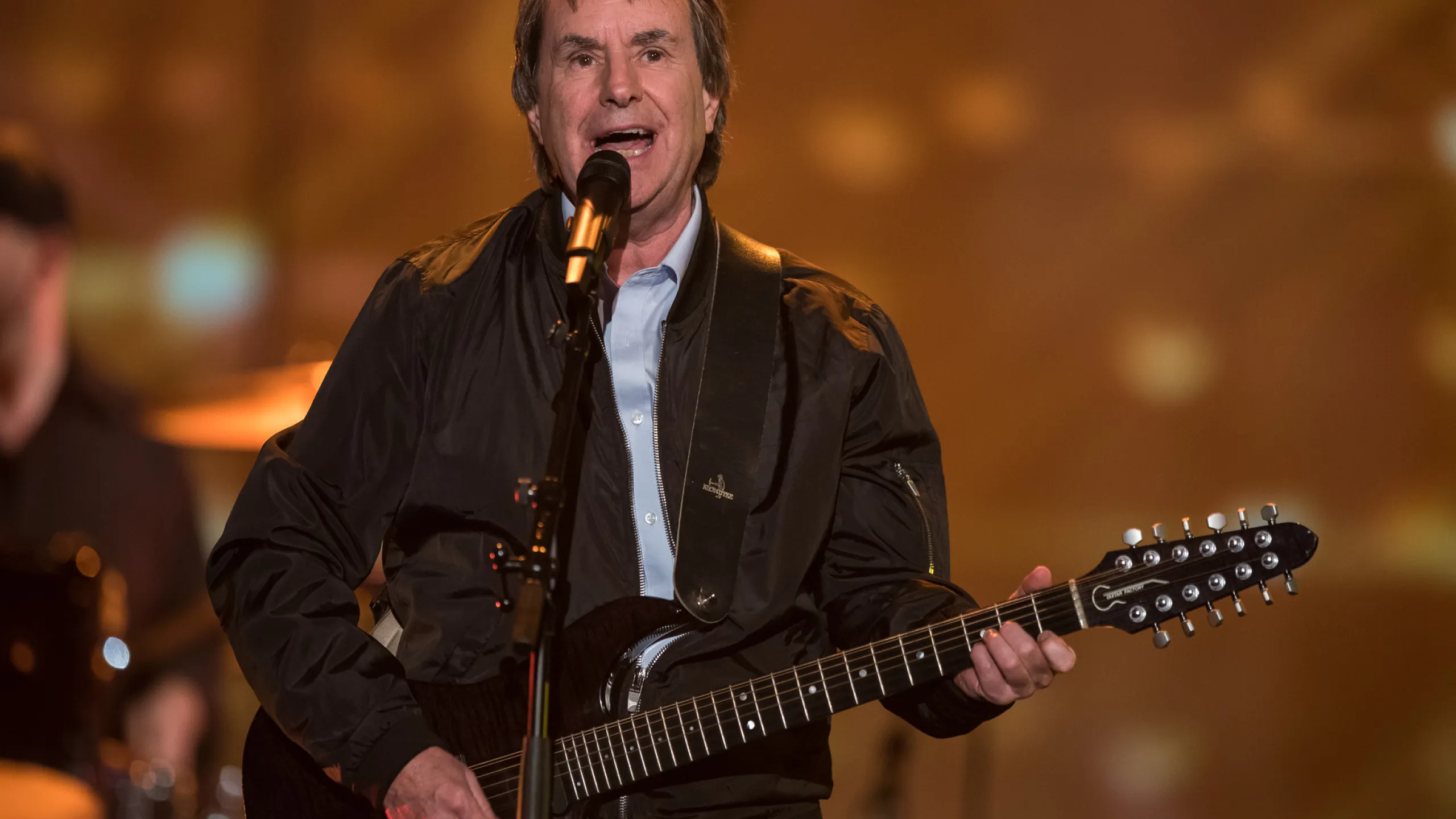 Chris de Burgh playing guitar and singing