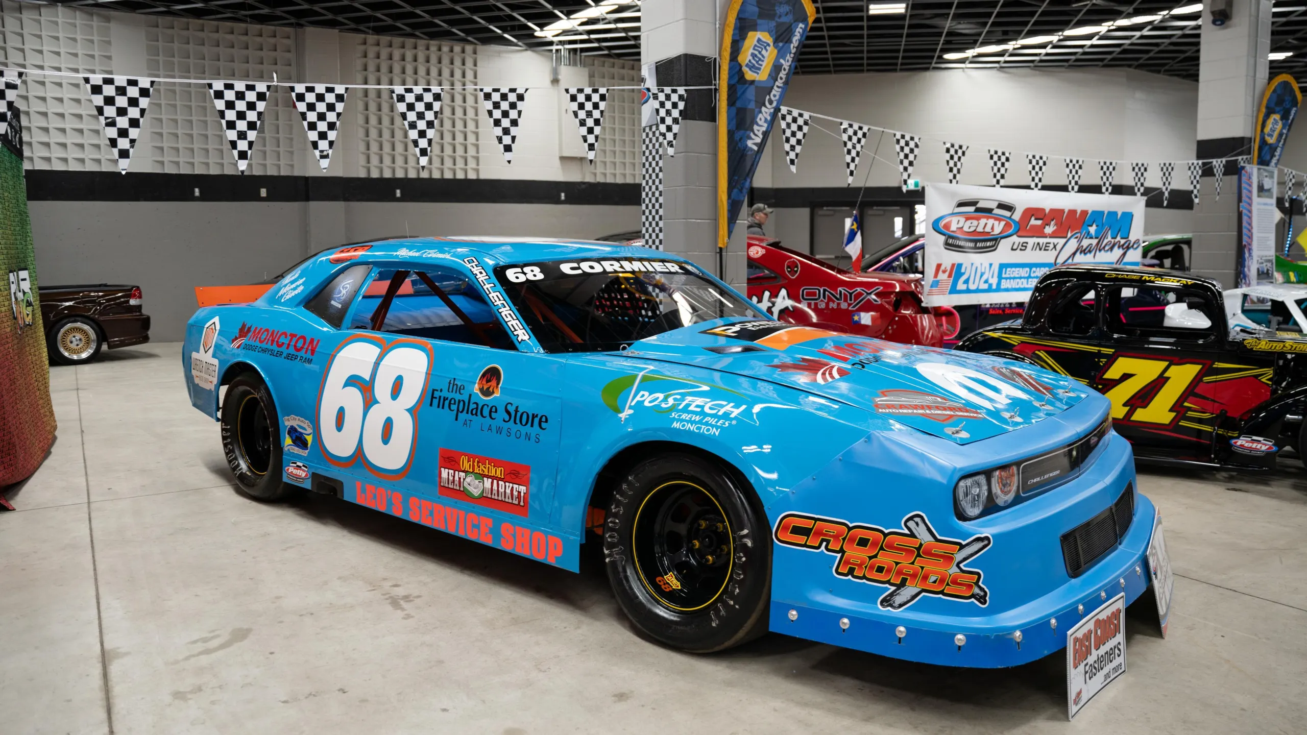 A bright blue stock racing car on display at an auto expo 