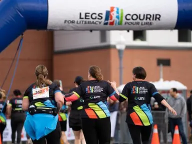 A group of runners racing toward the finish line at Legs for Literacy.