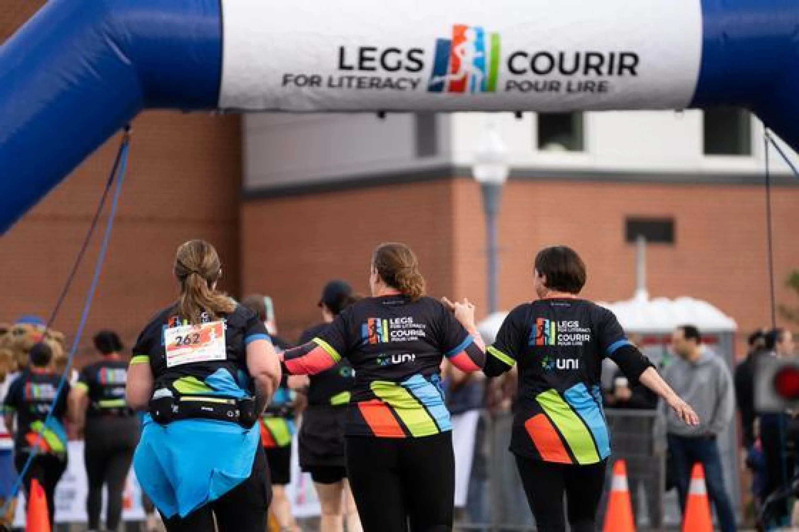 A group of runners racing toward the finish line at Legs for Literacy.